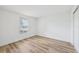 Bright bedroom featuring light wood floors, a window with blinds, and white walls at 622 Cedar Grove Dr, Brandon, FL 33511