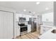 Well-lit kitchen featuring stainless steel appliances, bright white cabinets, and light countertops at 622 Cedar Grove Dr, Brandon, FL 33511