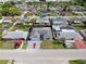 Aerial view of home and neighborhood shows gray roof, fenced in yard, nice landscaping, and painted driveway at 6240 Keller Dr, Port Richey, FL 34668