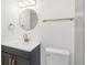 Bright bathroom with gold accents, a round mirror, and a modern sink and vanity at 6240 Keller Dr, Port Richey, FL 34668