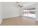 Bright bedroom with light wood floors, ceiling fan, and sliding glass door to the backyard pool at 6240 Keller Dr, Port Richey, FL 34668