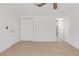 Neutral bedroom featuring wood flooring, ceiling fan, closet, and access to a bathroom at 6240 Keller Dr, Port Richey, FL 34668