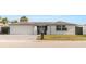 Charming one-story home featuring a large garage, tidy landscaping, and a freshly painted exterior at 6240 Keller Dr, Port Richey, FL 34668