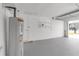 Inside the garage, epoxy flooring, a white interior, shelving and water heater are visible at 6240 Keller Dr, Port Richey, FL 34668