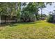 A spacious backyard featuring lush green grass, mature trees, and privacy fence at 6441 27Th N Ave, St Petersburg, FL 33710