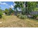 A spacious backyard featuring lush green grass, mature trees, and privacy fence at 6441 27Th N Ave, St Petersburg, FL 33710