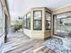 Spacious screened back porch boasts wood-look tile flooring, a fan, and exterior views at 66 Bay Woods Dr, Safety Harbor, FL 34695