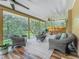 Large screened-in porch with comfortable seating, fan, and a serene outdoor view at 66 Bay Woods Dr, Safety Harbor, FL 34695