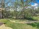 Beautiful backyard with terraced landscaping, mature trees, and lush green lawn at 66 Bay Woods Dr, Safety Harbor, FL 34695
