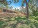 Spacious backyard featuring a multi-tiered retaining wall and a screened-in porch, perfect for outdoor relaxation at 66 Bay Woods Dr, Safety Harbor, FL 34695
