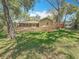 A large yard features terraced stone landscaping, mature trees, and a screened back porch at 66 Bay Woods Dr, Safety Harbor, FL 34695