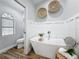 Bright bathroom featuring a freestanding tub, shiplap accent wall, and modern fixtures at 66 Bay Woods Dr, Safety Harbor, FL 34695