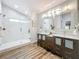 Modern bathroom showcasing double sinks, sleek mirrors, and glass-enclosed shower at 66 Bay Woods Dr, Safety Harbor, FL 34695