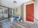 Inviting front porch features a vibrant red door, stylish seating, and decorative accents at 66 Bay Woods Dr, Safety Harbor, FL 34695