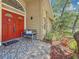 Inviting front porch with a vibrant red door, decorative tile flooring, and comfortable seating area at 66 Bay Woods Dr, Safety Harbor, FL 34695