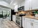 Well-lit kitchen featuring stainless steel appliances, granite countertops, and white cabinetry at 66 Bay Woods Dr, Safety Harbor, FL 34695