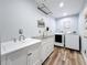 Clean laundry room featuring a sink, stainless countertop, washer, and dryer at 66 Bay Woods Dr, Safety Harbor, FL 34695