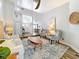 Open-concept living room with wood-look tile flooring, comfortable seating, and a view into the dining area at 66 Bay Woods Dr, Safety Harbor, FL 34695