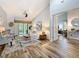 Bright living room with vaulted ceilings, wood-look tile flooring, and a sliding glass door to the outdoors at 66 Bay Woods Dr, Safety Harbor, FL 34695