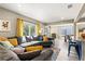 Cozy living room filled with natural light, yellow curtains and an expansive sectional sofa at 715 39Th Ne Ave, St Petersburg, FL 33703