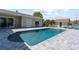 Inviting in-ground pool surrounded by gray stone patio with a backdrop of palm trees and manicured landscaping at 715 39Th Ne Ave, St Petersburg, FL 33703
