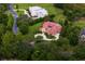 Aerial shot showcases the house with its sprawling lot, circular driveway, lush landscaping, and a sparkling pool at 7713 Still Lakes Dr, Odessa, FL 33556