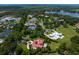 Aerial view of a luxury home in a beautiful community near a lake surrounded by trees at 7713 Still Lakes Dr, Odessa, FL 33556