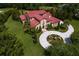 Beautiful home with a circular driveway, lush landscaping, and a red tile roof at 7713 Still Lakes Dr, Odessa, FL 33556