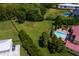 Aerial view of a large, grassy backyard with a luxurious pool and manicured landscaping at 7713 Still Lakes Dr, Odessa, FL 33556