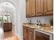 Butler's pantry area with granite countertop, wine fridge, and custom cabinetry at 7713 Still Lakes Dr, Odessa, FL 33556