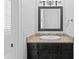 Bathroom with granite countertop, dark cabinets, and decorative mirror at 7713 Still Lakes Dr, Odessa, FL 33556