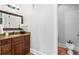 Modern bathroom features a sleek vanity with granite counters, dark wood cabinets and views of the toilet area at 7713 Still Lakes Dr, Odessa, FL 33556