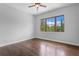 A bright bedroom with hardwood floors and a large window overlooking lush greenery at 7713 Still Lakes Dr, Odessa, FL 33556