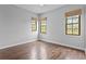 Light bedroom featuring hardwood floors and three windows with natural shades at 7713 Still Lakes Dr, Odessa, FL 33556