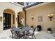 Charming courtyard featuring a wrought iron table set, decorative fountain, and stucco walls with elegant lighting at 7713 Still Lakes Dr, Odessa, FL 33556