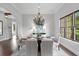 Open dining room with chandelier, hardwood floors, and bright natural light at 7713 Still Lakes Dr, Odessa, FL 33556