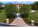 View of driveway leading to a beautiful home, surrounded by manicured trees and lush landscaping at 7713 Still Lakes Dr, Odessa, FL 33556