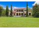 Beautiful two-story home with a red tile roof and black iron fence surrounding the property at 7713 Still Lakes Dr, Odessa, FL 33556