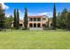 Elegant home with a tile roof, balconies, pool, and large yard, offering luxury and outdoor enjoyment at 7713 Still Lakes Dr, Odessa, FL 33556