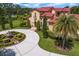 Beautiful home with lush landscaping, a circular driveway, and a red tile roof at 7713 Still Lakes Dr, Odessa, FL 33556