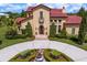 Elegant home featuring a red tile roof, stucco walls, and a beautifully landscaped front yard at 7713 Still Lakes Dr, Odessa, FL 33556