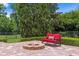 Brick patio featuring a fire pit and comfortable seating, ideal for outdoor gatherings and relaxation at 7713 Still Lakes Dr, Odessa, FL 33556