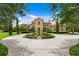 Home exterior with circular driveway, fountain, and lush landscaping at 7713 Still Lakes Dr, Odessa, FL 33556