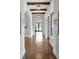 Long hallway with hardwood floors, wooden beams, and views of the pool at 7713 Still Lakes Dr, Odessa, FL 33556
