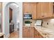 Charming kitchen features granite countertops, custom cabinets, and stainless microwave at 7713 Still Lakes Dr, Odessa, FL 33556