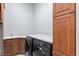 Functional laundry room with modern appliances, cabinets, counter space, and a utility sink for added convenience at 7713 Still Lakes Dr, Odessa, FL 33556