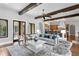 Open-concept living room with wood beams and hardwood floors adjacent to a kitchen at 7713 Still Lakes Dr, Odessa, FL 33556
