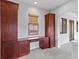 Office featuring custom built-in desk and storage with arched doorway and neutral carpet at 7713 Still Lakes Dr, Odessa, FL 33556