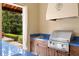 Close-up of the outdoor kitchen featuring a stainless steel grill and sink, perfect for outdoor cooking at 7713 Still Lakes Dr, Odessa, FL 33556