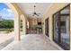 Covered outdoor kitchen with bar seating, ideal for al fresco dining, featuring access to pool and beautiful backyard at 7713 Still Lakes Dr, Odessa, FL 33556